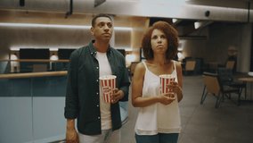 A couple with popcorn chooses a movie to watch. High quality 4k footage