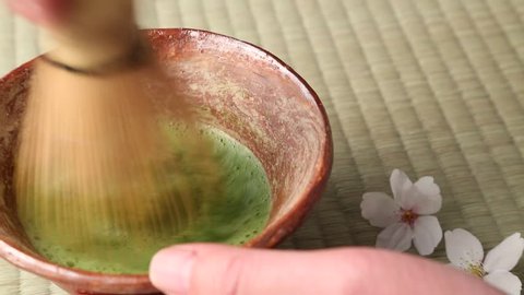 Male hand preparing Matcha green tea on Tatami mat