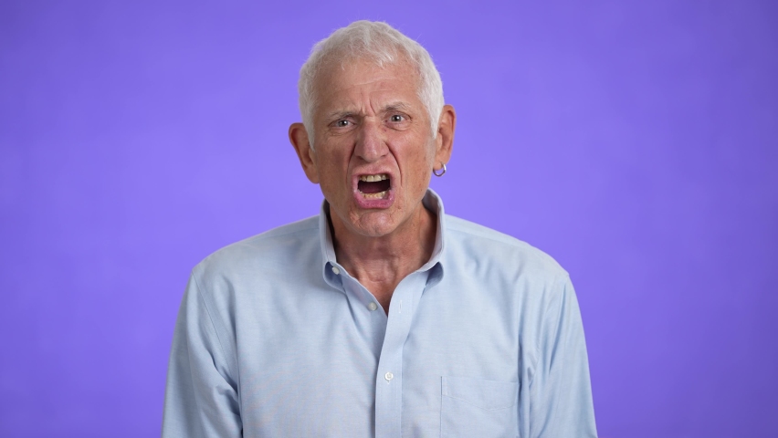 Displeased irritated sad angry elderly gray-haired man 70s wears blue shirt yell scream isolated on plain light purple background studio portrait | Shutterstock HD Video #1094470575