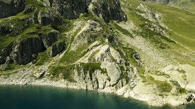 Drone footage of a mountain in pyrenees in france in a beautiful valley with a big lake in slowmotion.