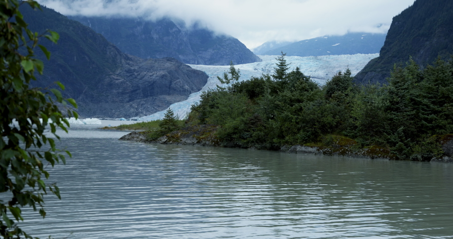 Mendenhall Glacier peeks out from outcropping under overcast sky Royalty-Free Stock Footage #1094473747