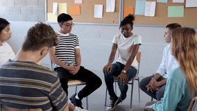 Teen black female talking about struggles in group therapy. Teen hispanic boy showing support. Mental health. 4k video.