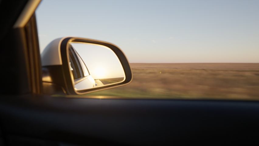 View from the side window of a car driving fast along the highway during a beautiful sunset. Travel trip and adventure concept. Royalty-Free Stock Footage #1094476917