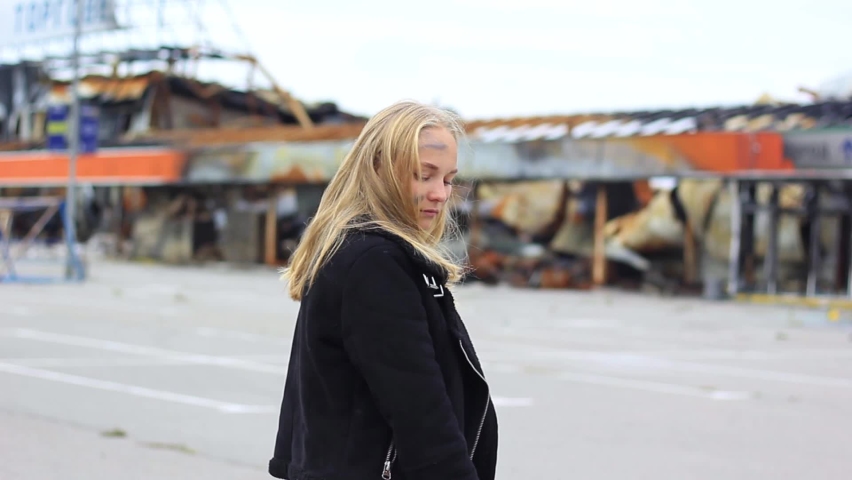 Portrait of one lonely young girl in soot against the background of a broken building