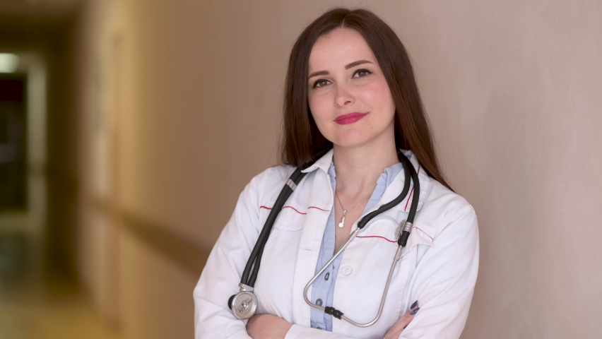 Portrait of smiling female doctor in medical Uniform standing in hospital corridor looking at camera with stethoscope. Health care and medical concept. Medical workers. Royalty-Free Stock Footage #1094481783