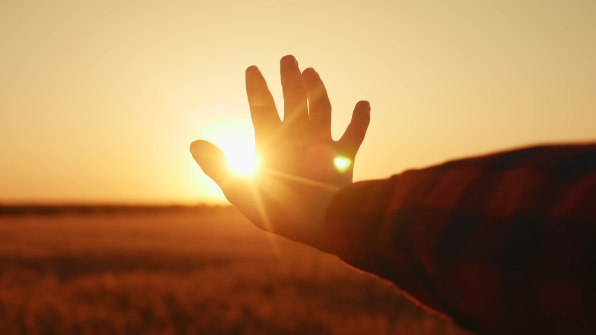 hand reaches for the sun. religion life freedom concept. girl pulls her hand to the sun at sunset close-up nature energy. religion lifestyle work on oneself concept
