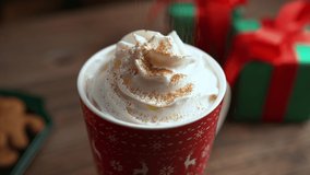 Sprinkling Cinnamon over Whipped Cream in a Red Mug Filled with Hot Chocolate - Christmas Dessert by the Fireplace - Powered by Shutterstock - Get 15% off with code: PIKWIZARD15