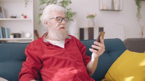 Senior man using smartphone to call a friend, online consultation, video call