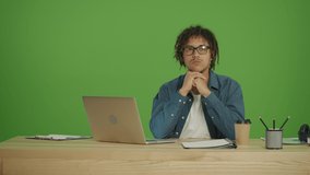 Young Tired Multicultural Freelancer Business Man Student in Denim Shirt and Glasses Sitting in front of Laptop and Thinking About Future Planning,Work Planning on Green Screen Background, Close view