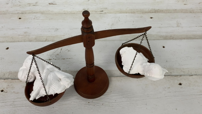 Broken family statuette on the scales of justice in a divorce custody battle | Shutterstock HD Video #1094496367
