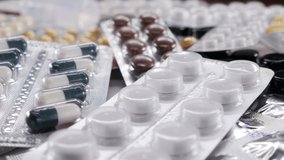 Blisters with medicines on the table. Close-up. Falling pills. The concept of the healthcare industry. Pharmaceutical, medical capsules, tablets fall on the table. Medicinal components, capsules with - Powered by Shutterstock - Get 15% off with code: PIKWIZARD15