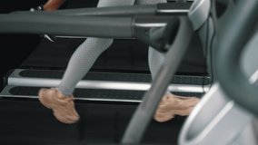 Leg shot of two female and male friends running on treadmills at gym. Group workout. Cardio training exercise. Horizontal video. High quality 4k footage