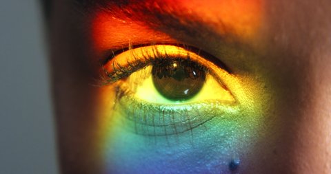 Beauty, rainbow and the eye of woman with a prism light reflection. Creative makeup, gay lifestyle and neon eye cosmetics for lgbt pride. Vision, eyesight and beautiful eyes and eyebrow on black girl Video Stok