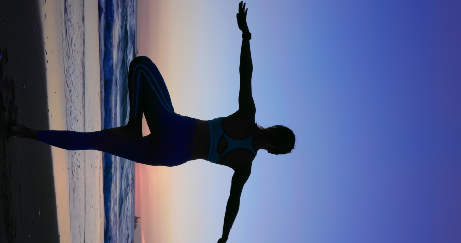 vertical silhouette of Asian healthy woman is practicing yoga and meditation on beach in the dusk Royalty-Free Stock Footage #1094505149