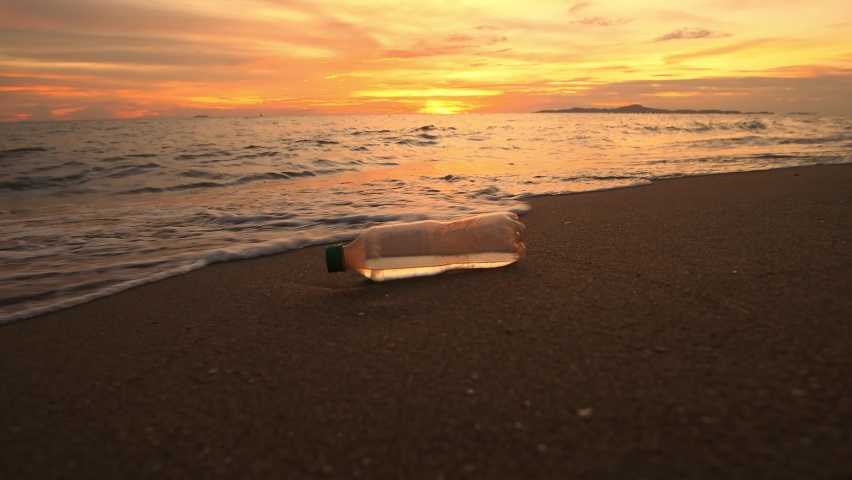 Plastic bottles garbage on sand beach is environment pollution of global with sunset sky background. Royalty-Free Stock Footage #1094506323