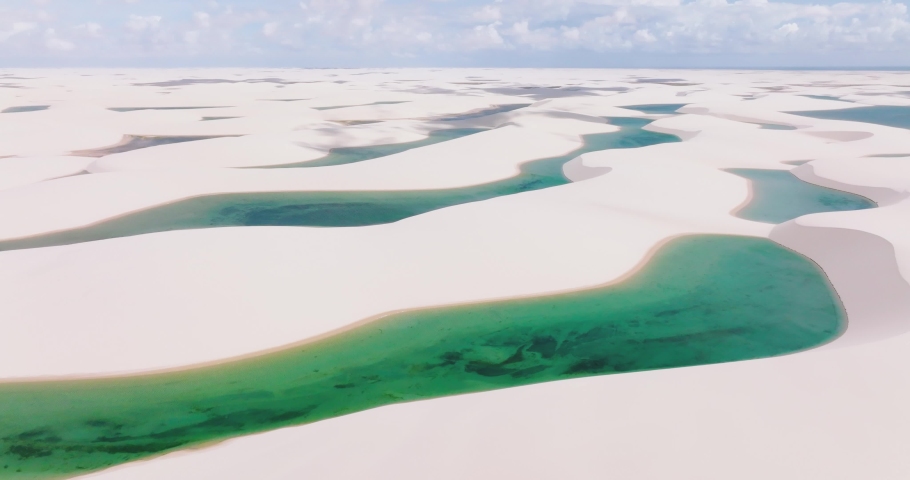 Aerial view overlooking rainwater pools and dunes in Parque Nacional dos Lençóis Maranhenses. sunny Brazil