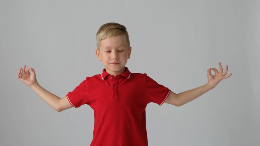 Caucasian child blond boy in doing yoga meditation, isolated over the white background. | Shutterstock HD Video #1094510919