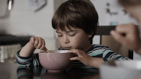 Little Hungry Boy Eating Breakfast Corn Cereal From Plate Sitting Home at Table in Kitchen. Child Eat Cornflakes with Milk. Healthy Nutrition Flakes. Portrait of Kid Eating Eating Muesli for Breakfast - Powered by Shutterstock - Get 15% off with code: PIKWIZARD15