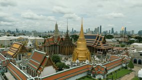 4K Cinematic urban drone footage of an aerial view of the temple of Wat Phra Kaew and The Grand Palace in the middle of the old town of Bangkok, Thailand on a sunny day.