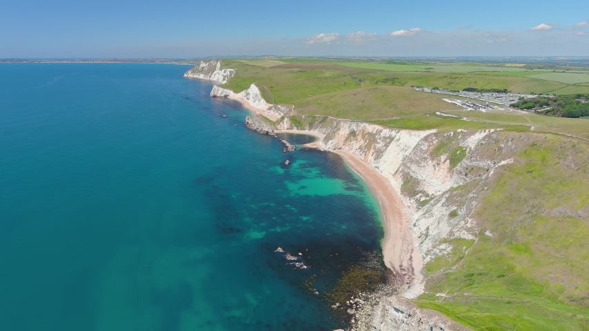 Durdle Door, UK: Aerial view of famous rock formation (limestone arch) on Jurassic Coast - landscape panorama of United Kingdom from above
