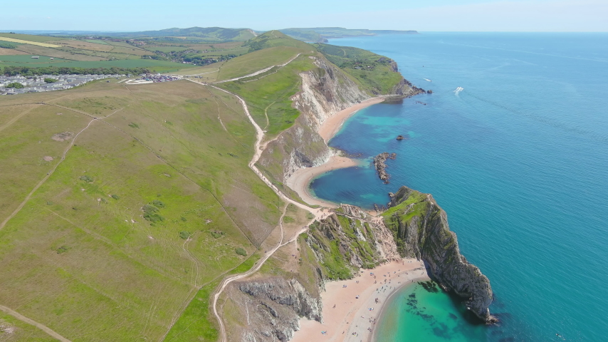 Durdle Door, UK: Aerial view of famous rock formation (limestone arch) on Jurassic Coast - landscape panorama of United Kingdom from above