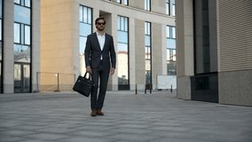 Successful confident stylish handsome caucasian businessman walking on street against background office building. - Powered by Shutterstock - Get 15% off with code: PIKWIZARD15