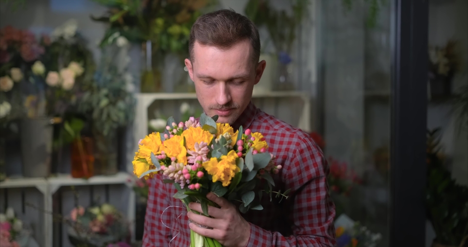 Dating, love, romantic or International Women's Day concept. Bearded florist male in shirt greeting with beautiful bouquet of spring yellow and pink flowers. High quality 4k video footage Royalty-Free Stock Footage #1094530869
