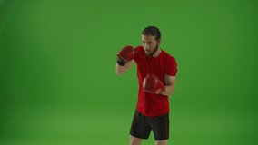 Young Professional Bearded Fighter Doing Boxing Exercises while Wearing Sportswear and Fighting Gloves on a Green Screen, Chroma Key.Strong Man Kickboxing and Self Defense Workout,Sport Concept - Powered by Shutterstock - Get 15% off with code: PIKWIZARD15