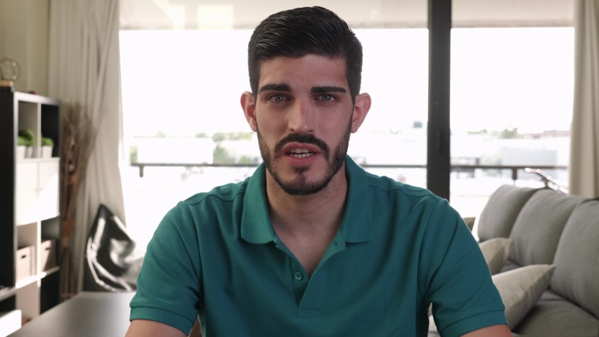 close-up portrait of young adult male speaking to camera and smiling 
