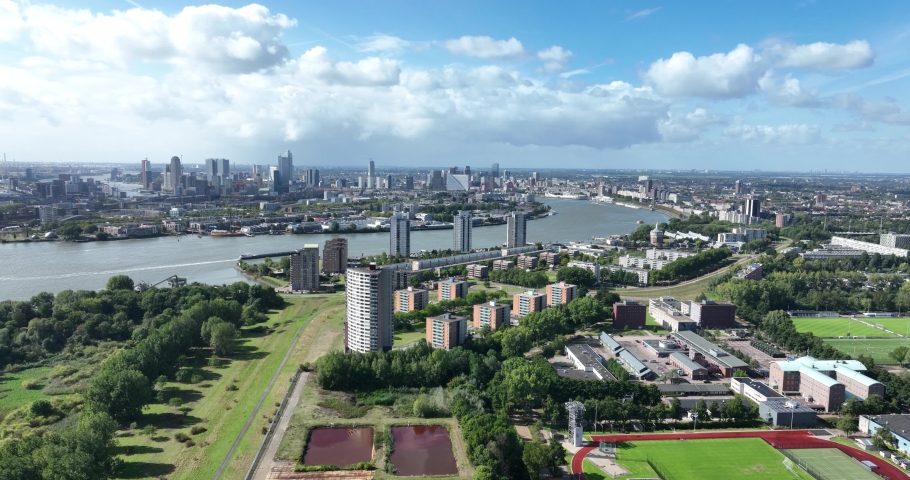 Rotterdam Feijenoord area of the municipality of Rotterdam on the south bank of the Nieuwe Maas river. City center skyline in the distance. Aerial drone overview. The Netherlands large urban city. Royalty-Free Stock Footage #1094539697