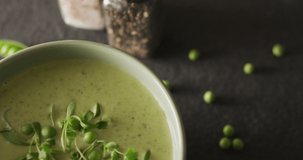 Video of green peas soup in bowl on grey table. American cuisine, meal, food and cooking concept.