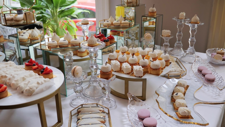 White Candy Bar Wedding Catering. Candy buffet, delicious sweet snacks, candy bar with cupcakes, cakepops, macaroons, cake, bize and other sweets cookies Banquet Hall. Event. Business Party. Birthday. | Shutterstock HD Video #1094542135