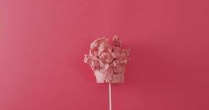 Video of marshmallow on stick lying on pink surface. Food, meal, sweets, cuisine and cooking concept.