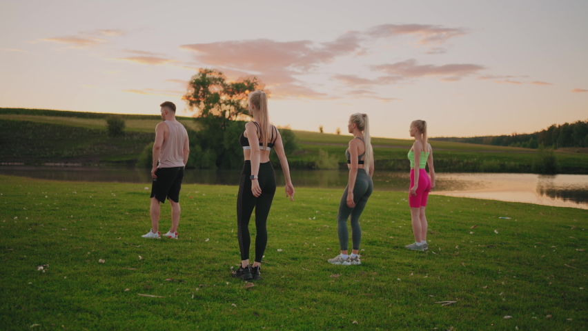 Group fitness practice in park, three blonde woman are squatting, training muscles of buttocks | Shutterstock HD Video #1094543535
