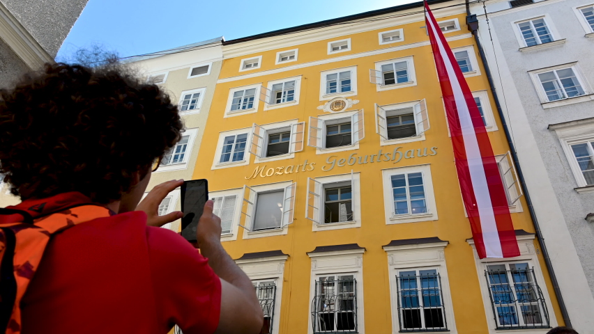 Salzburg, Austria, August 15, 2022. A cute boy is photographing mozart