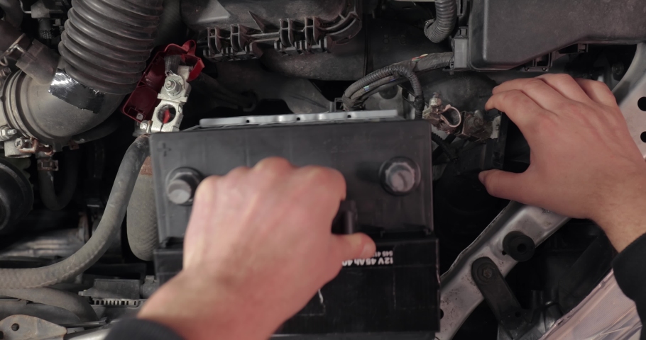 Replacing starter battery in a car, installing new one for reliable operation, connecting contact terminals Royalty-Free Stock Footage #1094547523