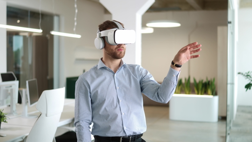Close up portrait of Caucasian young man working in modern big company office wearing VR glasses moving hands in air. Businessman works on a project using virtual reality headset. Technology concept Royalty-Free Stock Footage #1094547617