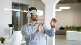 Close up portrait of Caucasian young man working in modern big company office wearing VR glasses moving hands in air. Businessman works on a project using virtual reality headset. Technology concept - Powered by Shutterstock - Get 15% off with code: PIKWIZARD15