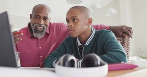 Video of happy african american father and son doing homework together. Family and spending quality time together.