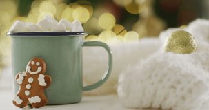 Video of gingerbread men and hot chocolate over christmas tree and lights. Christmas, tradition and celebration concept.
