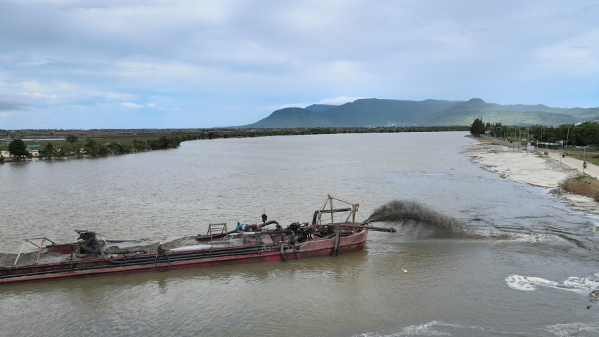 Aerial drone shot of dredging boat adding large quantities of sand to increase riverbank width Royalty-Free Stock Footage #1094552103