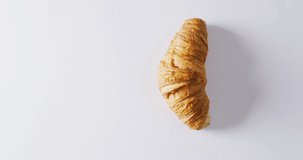 Video of close up of croissant with copy space on white background. Food and baking concept.