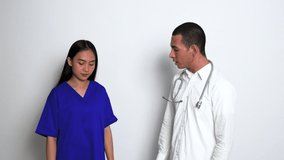 Video Footage From a Young Male Doctor Keep Scolding a Female Nurse While the Female Nurse Stay Silent as Form of Apology in a White Background