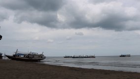 Time lapse of several fishing boats and sky on the beach
