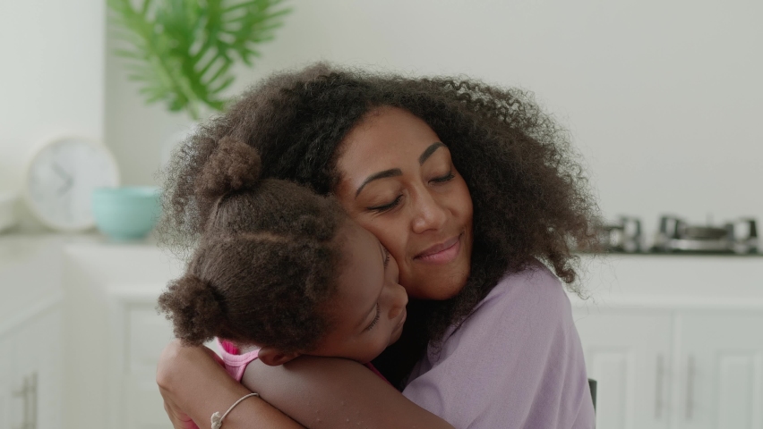 Close-up portrait of a happy African young woman, loving mom hugging her adorable elementary age daughter. Family relationships. Tenderness, togetherness, love, affection, care, happy motherhood | Shutterstock HD Video #1094559483