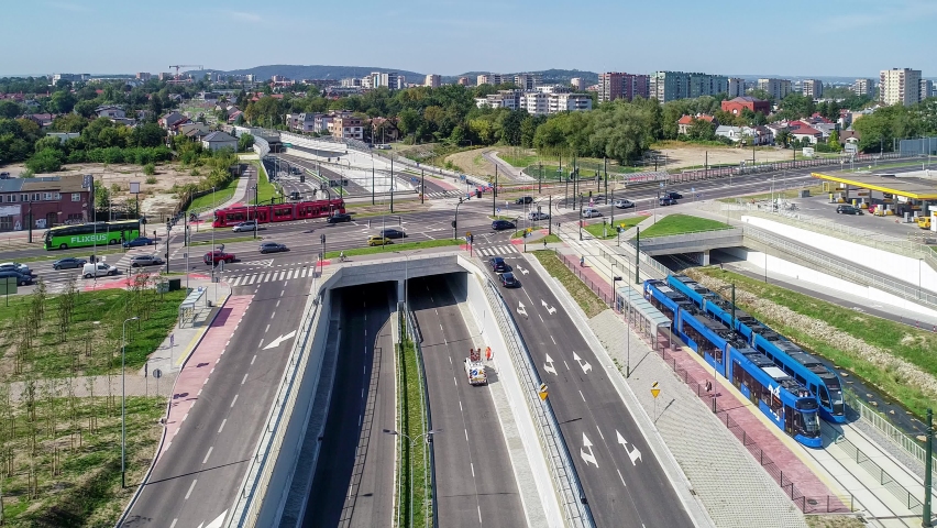 New city highway Trasa Lagiewnicka, Krakow, Poland, with tunnels, tramway, trams, slip roads, cycle path and walkway. Multilevel crossroad with Zakopianska street. River Wilga and railway. Aerial view Royalty-Free Stock Footage #1094560027