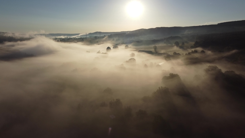 Fog in the valley of the Belgian Ardennes near Chevron, Liège. Aerial with beautiful sunbeams