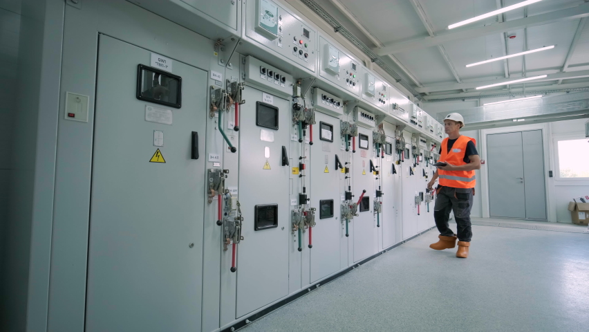 Electrical engineers inspect the electrical systems at the equipment control cabinet Royalty-Free Stock Footage #1094570991