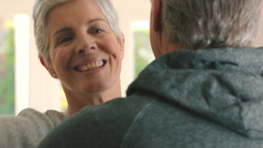 Hug, senior couple and love between partners feeling safe, security and happy in arms while bonding at home. Smile, happiness and joy in soulmate man and woman sharing understanding and commitment