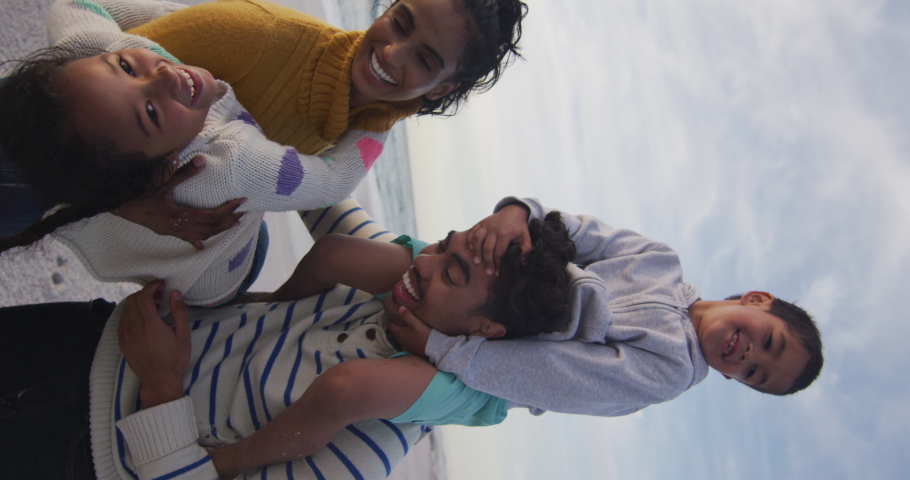 Vertical video of happy biracial family embracing on sunny beach. healthy, active time beach holiday. | Shutterstock HD Video #1094573273